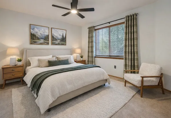 a bedroom with a bed and a large window