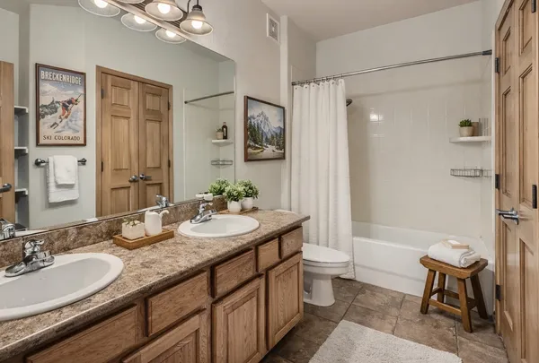 a bathroom with a granite countertop sink toilet a large mirror a shower and a mirror