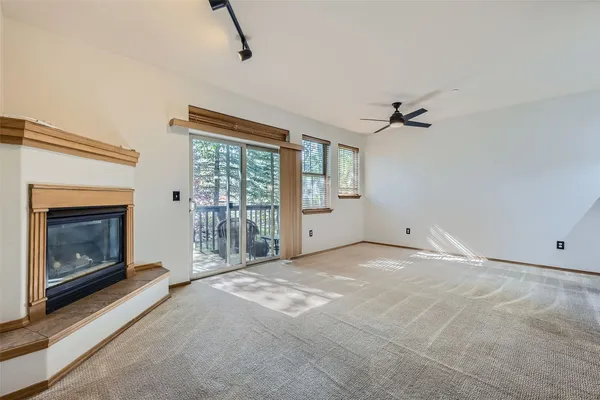 a view of empty room with fireplace and windows