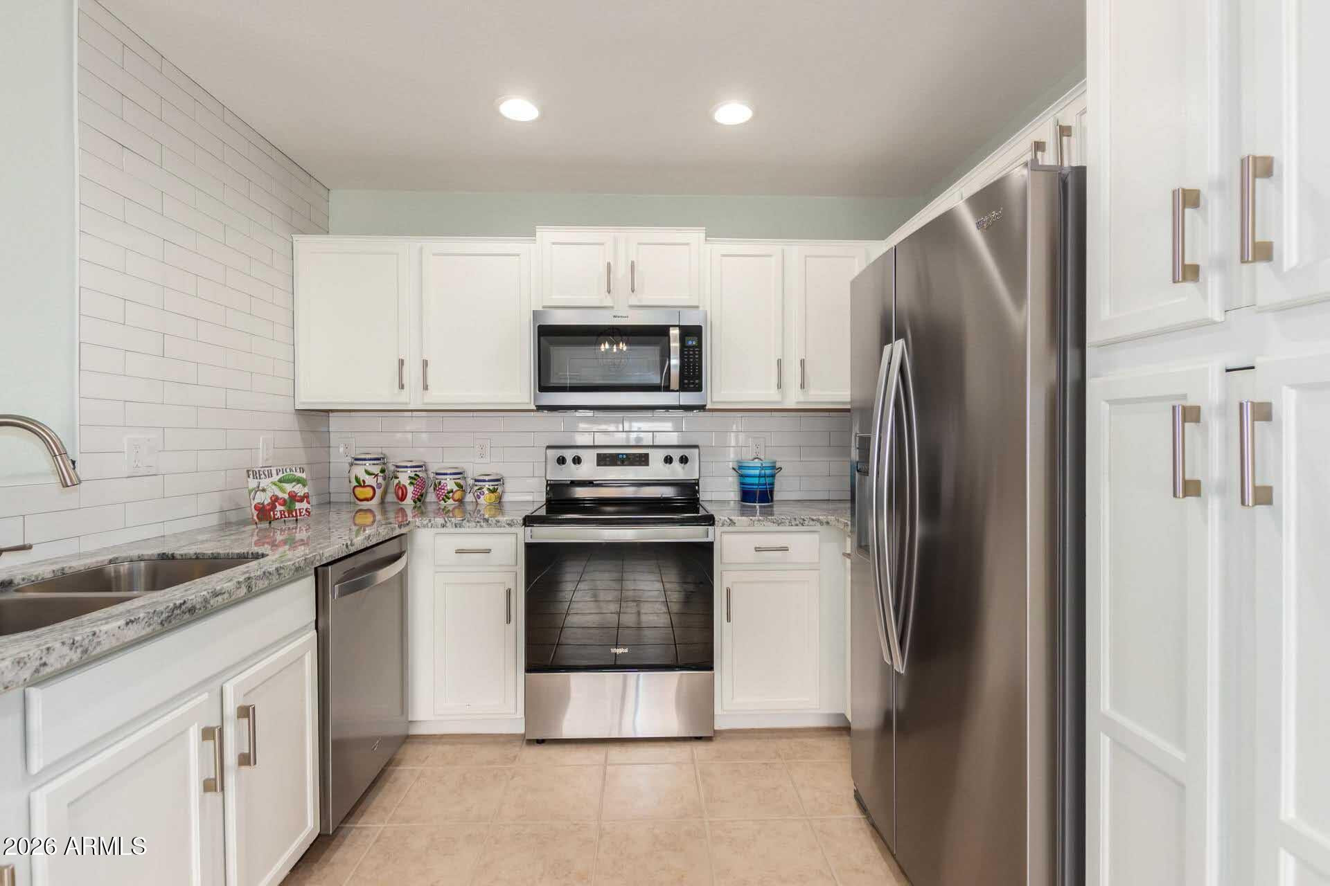 17618 West Calavar Road Surprise, AZ 85388 - Photo 12 of 24 a kitchen with a refrigerator sink and microwave