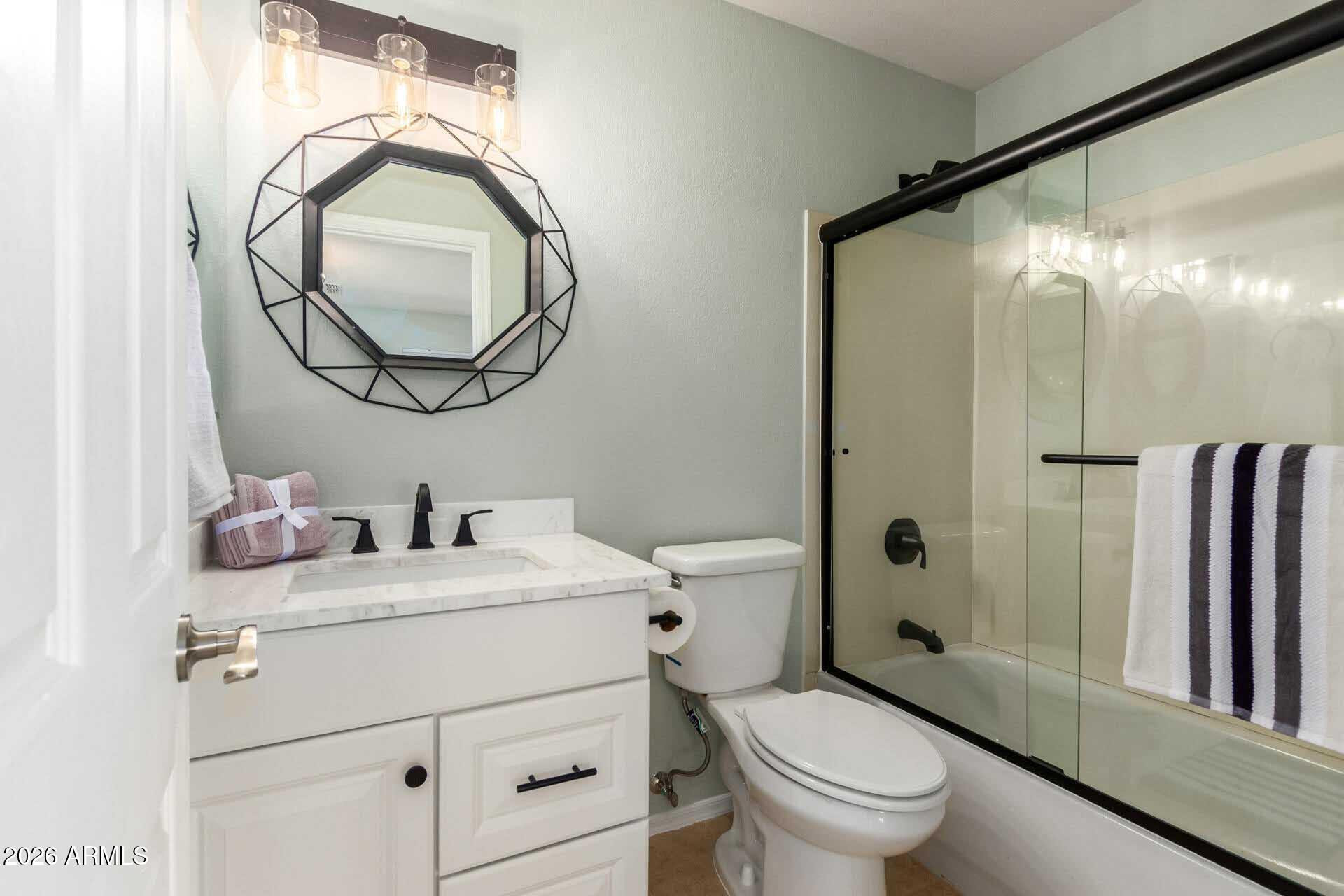 17618 West Calavar Road Surprise, AZ 85388 - Photo 15 of 24 a bathroom with a toilet a sink and a mirror