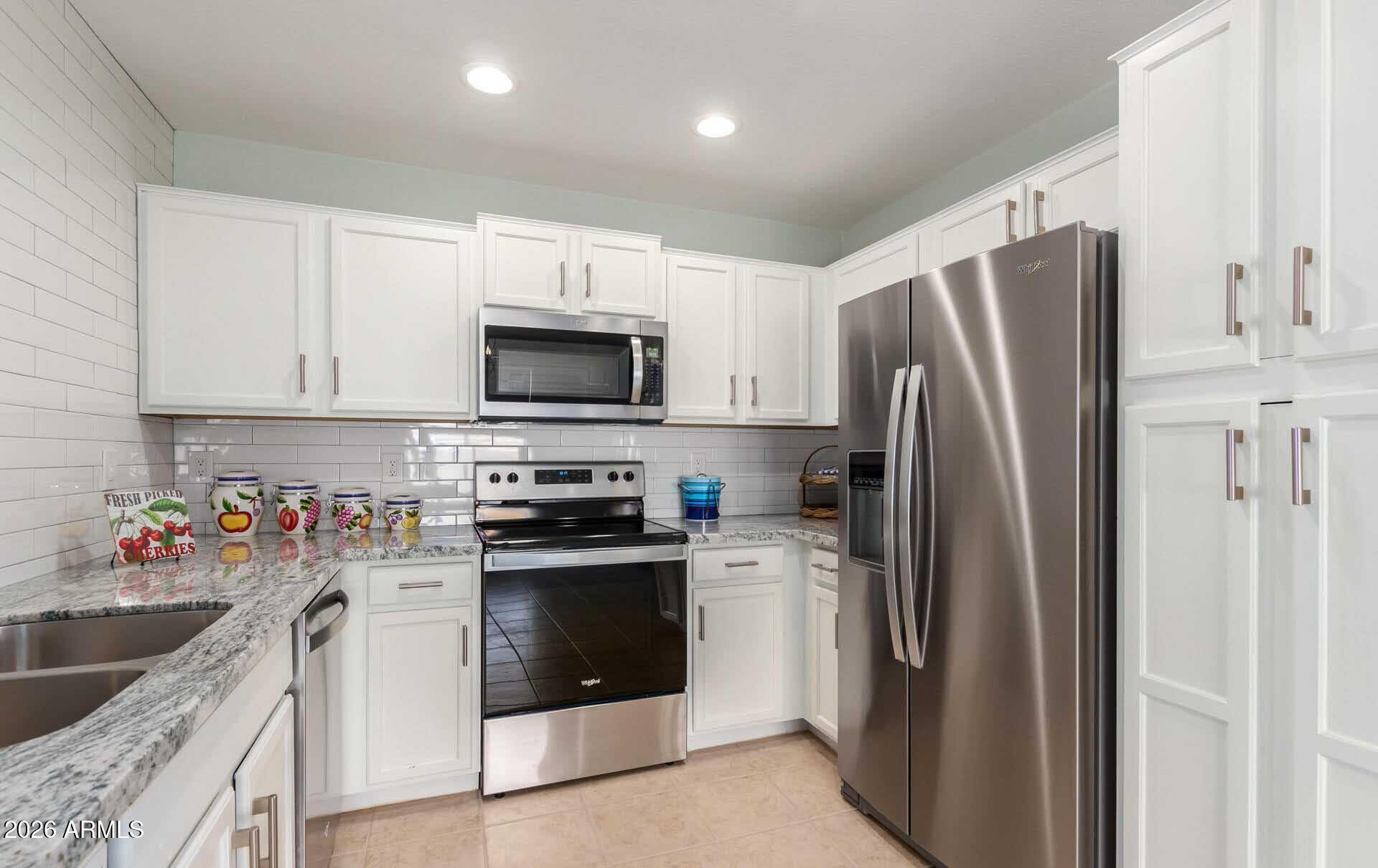 17618 West Calavar Road Surprise, AZ 85388 - Photo 10 of 24 a kitchen with stainless steel appliances a refrigerator sink and microwave