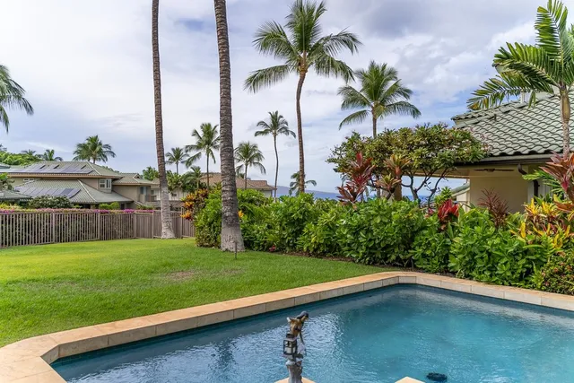 a front view of a house with a yard and garden