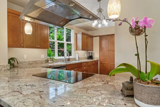 a kitchen with stainless steel appliances granite countertop a sink stove and cabinets