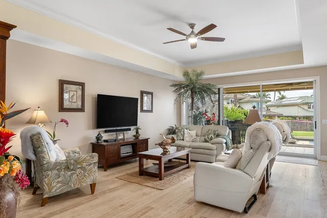 a living room with furniture a potted plant and a large window