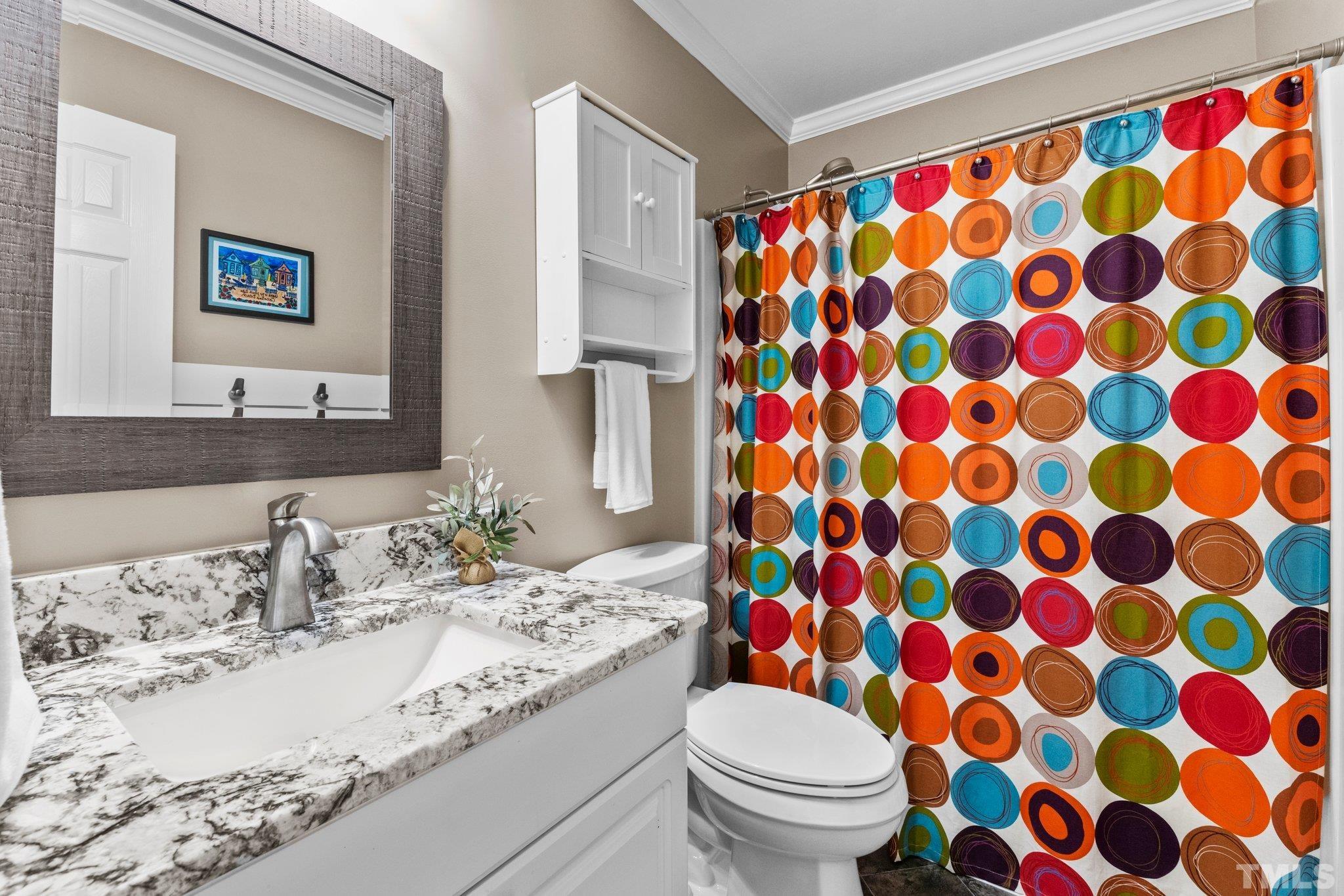 6304 Meerbrook Court Raleigh, NC 27603 - Photo 16 of 30 a bathroom with a granite countertop sink a toilet and a mirror