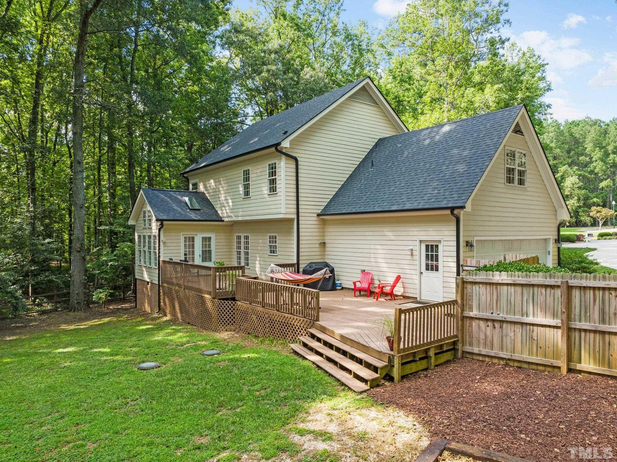 6304 Meerbrook Court Raleigh, NC 27603 - Photo 23 of 30 a view of a house with a yard and deck area under a large tree