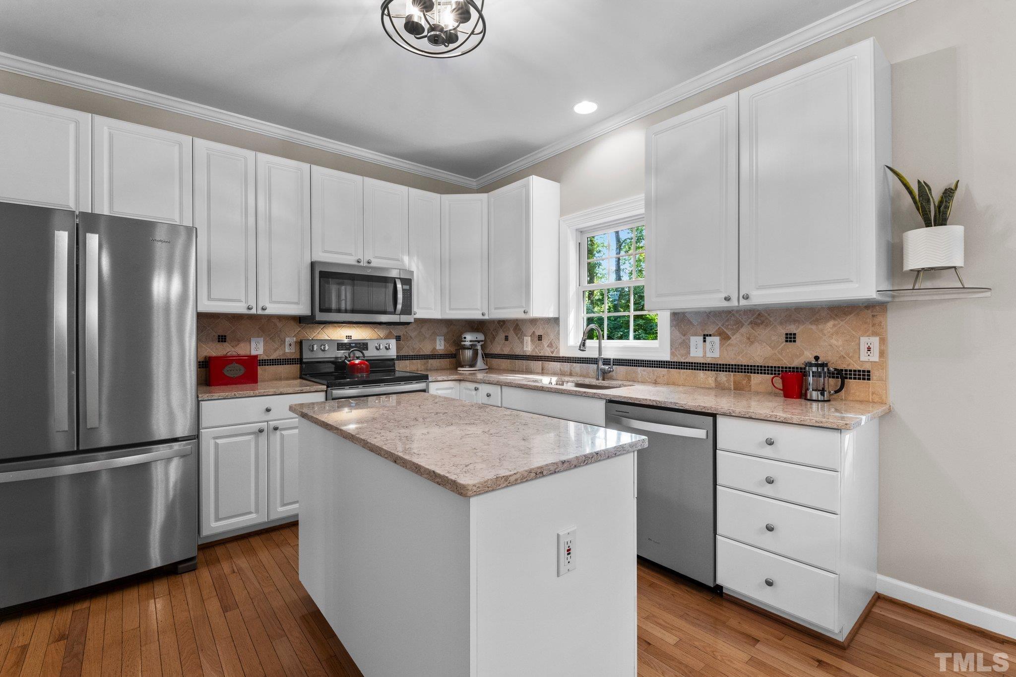 6304 Meerbrook Court Raleigh, NC 27603 - Photo 3 of 30 a kitchen with cabinets stainless steel appliances a sink and a stove