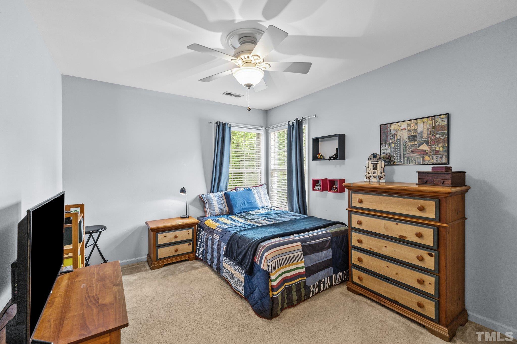 4009 Sunridge Road Raleigh, NC 27613 - Photo 29 of 35 a bedroom with a bed and a chandelier