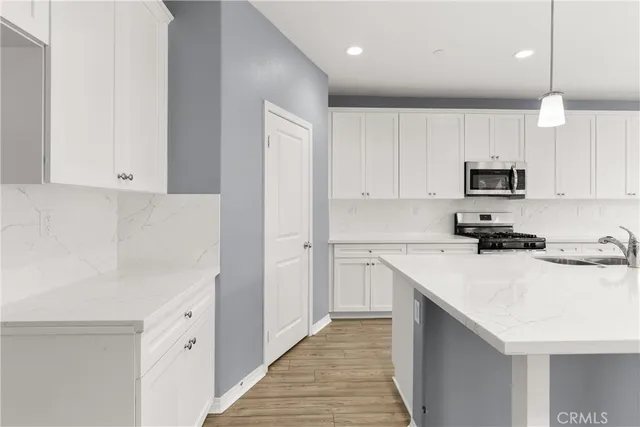 a kitchen with a sink stove and wooden floor