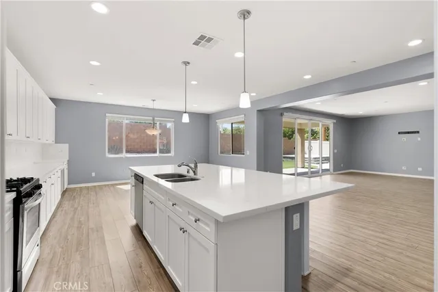 a kitchen with a stove a sink a refrigerator and a microwave