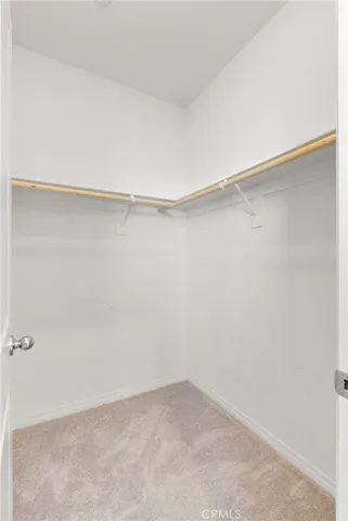 a view of an empty room with a window and a bathroom