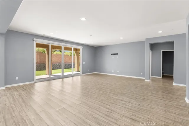 an empty room with wooden floor and window