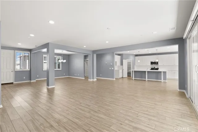 a large kitchen with stainless steel appliances granite countertop a stove a sink dishwasher and a refrigerator with wooden floor