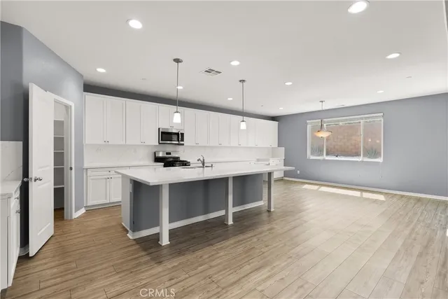 a kitchen with sink a microwave and cabinets