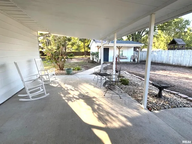 a view of a patio with chairs and floor to ceiling window