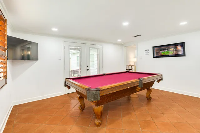 a room with pool table and windows