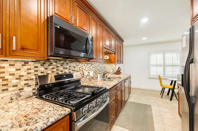 a kitchen with stainless steel appliances granite countertop a stove and a microwave