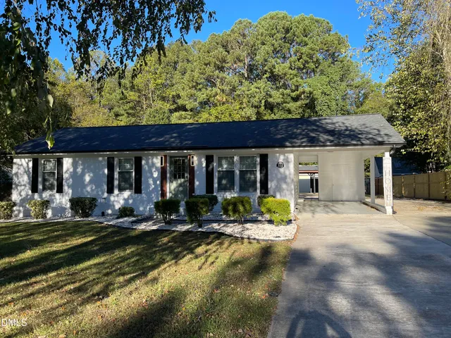 a view of a house with backyard sitting area and garden