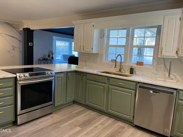 a kitchen with stainless steel appliances granite countertop a sink a stove a refrigerator and cabinets