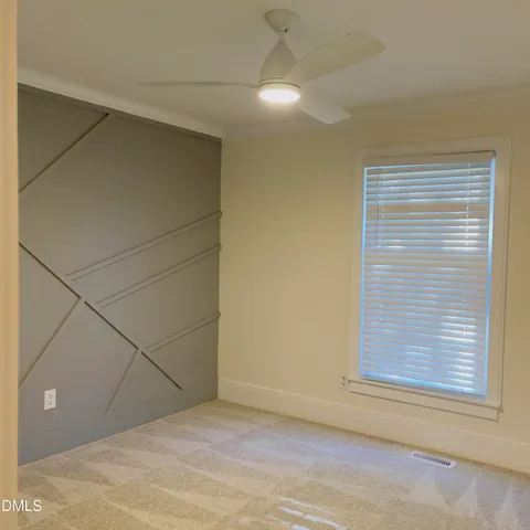 a view of an empty room with a window and closet area