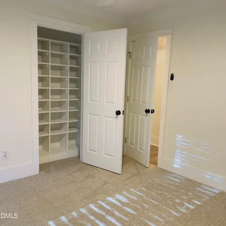 en empty room with windows and chandelier fan