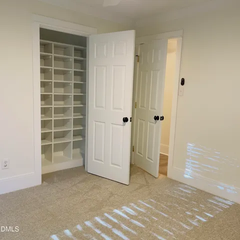 en empty room with windows and chandelier fan