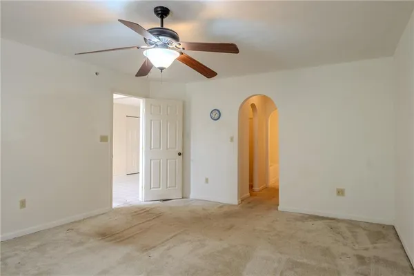 a view of a room with a chandelier fan and windows