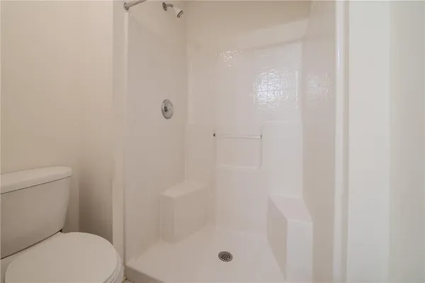 a bathroom with a shower a toilet and a sink