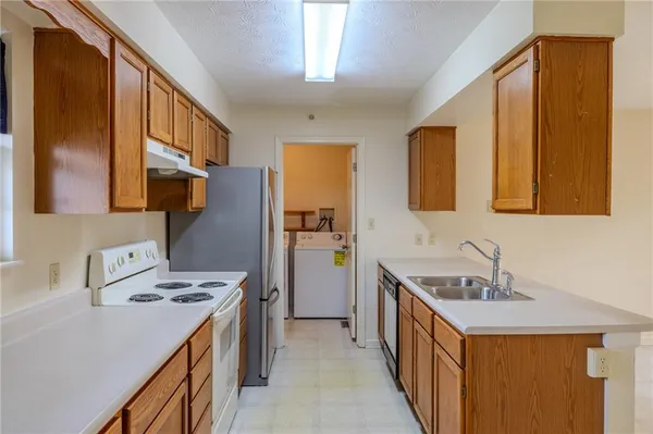 a kitchen with a sink stove and refrigerator