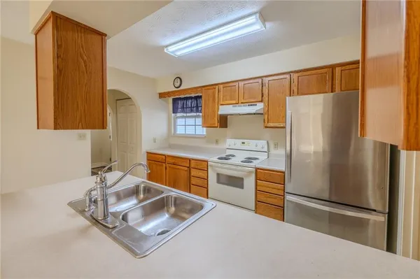 a kitchen with stainless steel appliances a refrigerator sink and stove