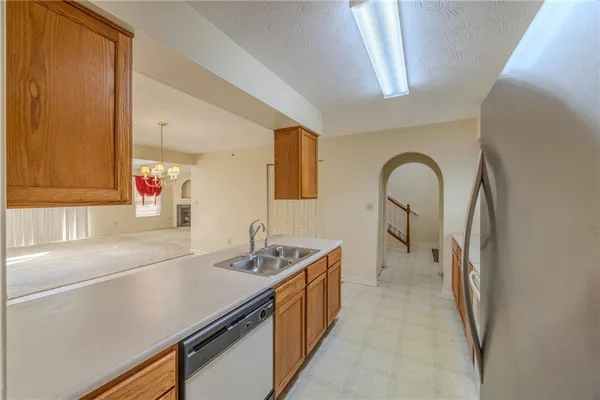 a hall with kitchen island a sink stove and a refrigerator