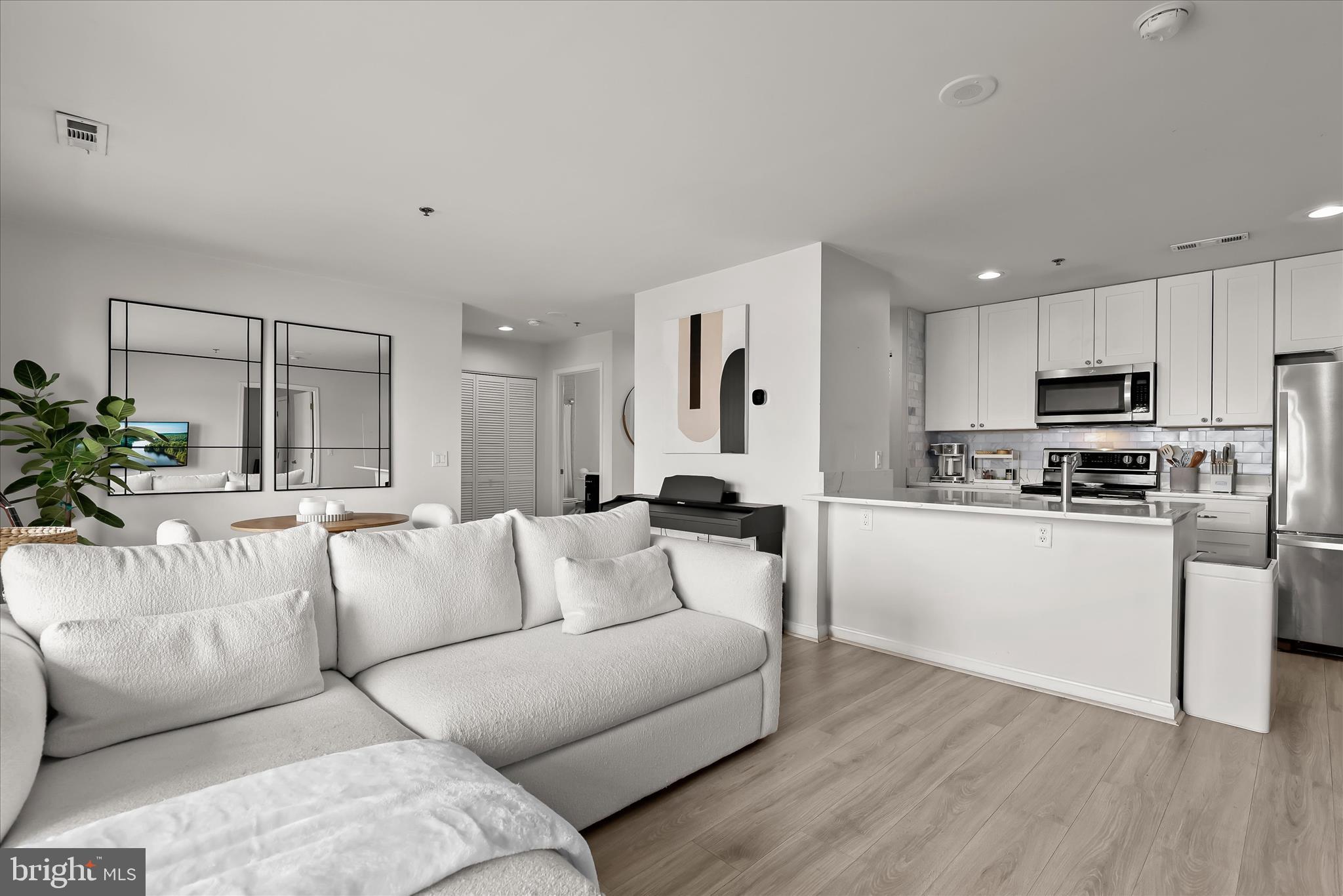 2702 Lighthouse Point East, Unit 522 Baltimore, MD 21224 - Photo 13 of 50 a living room with furniture and kitchen view