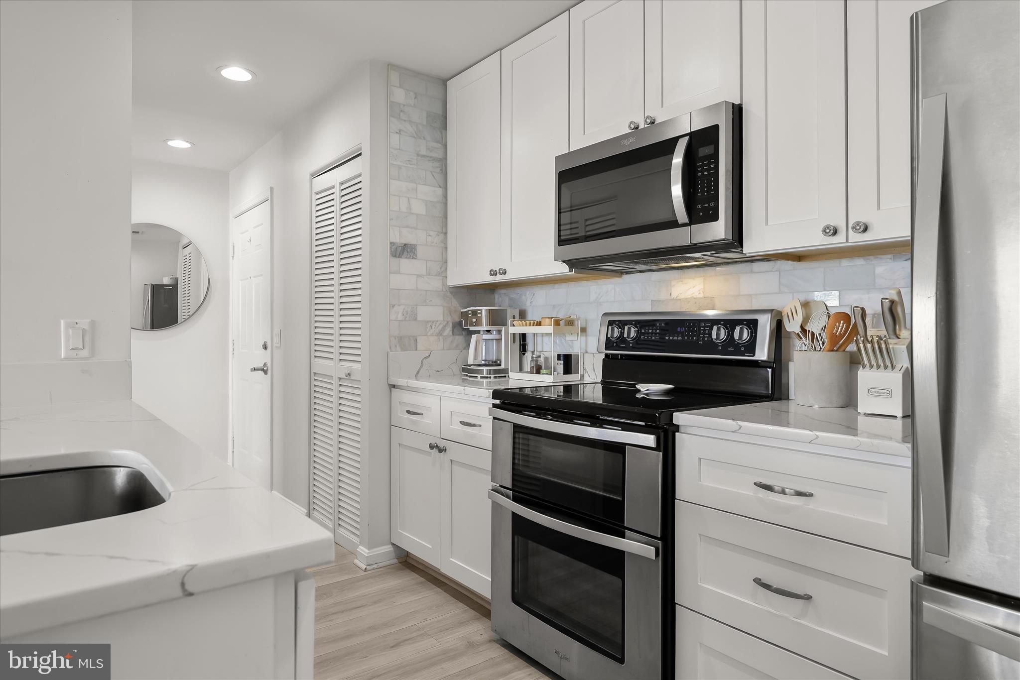 2702 Lighthouse Point East, Unit 522 Baltimore, MD 21224 - Photo 15 of 50 a kitchen with white cabinets stainless steel appliances and sink