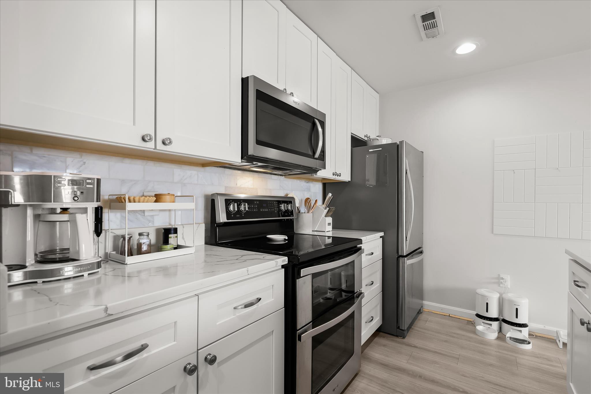 2702 Lighthouse Point East, Unit 522 Baltimore, MD 21224 - Photo 16 of 50 a kitchen with stainless steel appliances a stove microwave and refrigerator