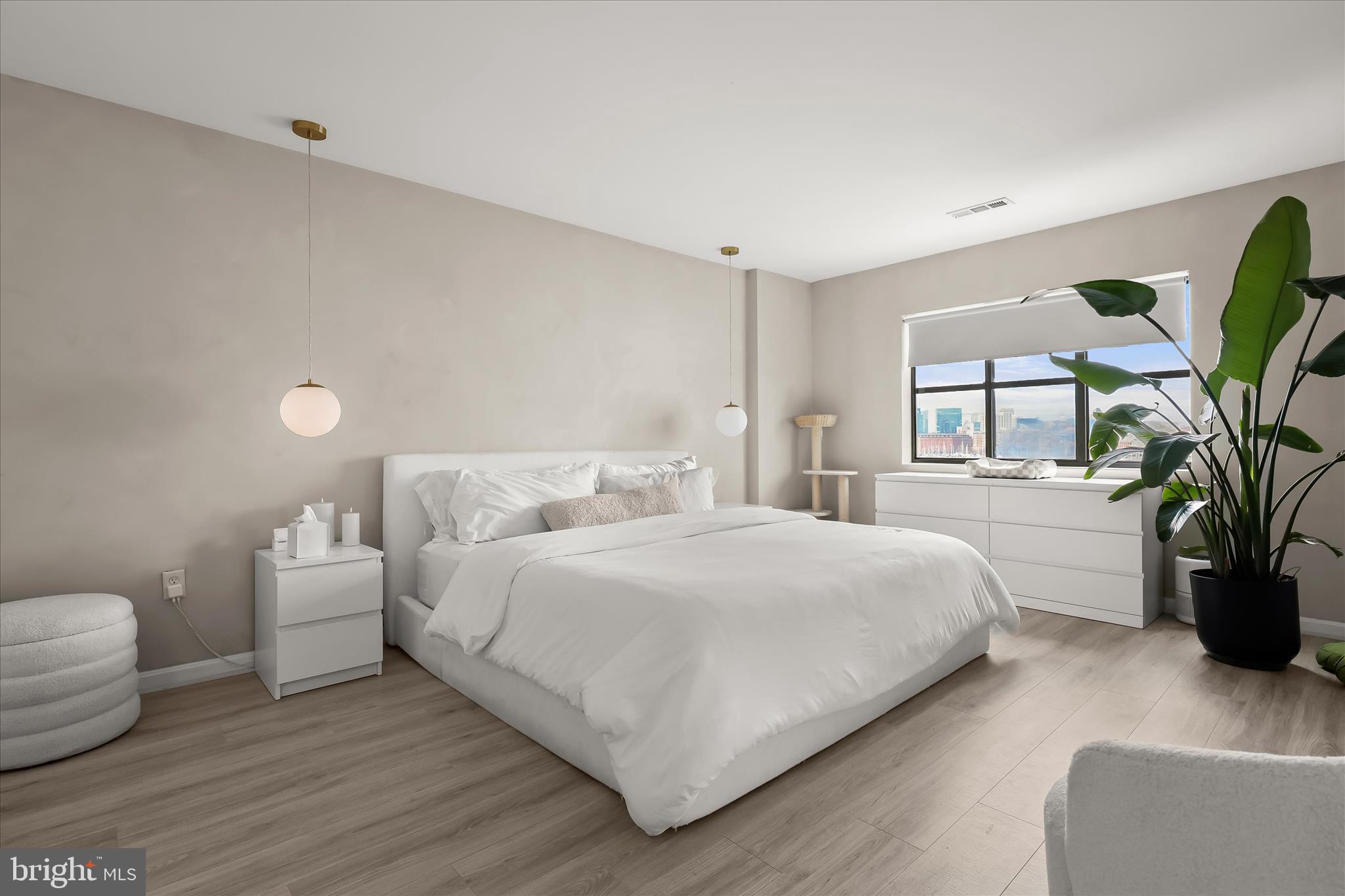 2702 Lighthouse Point East, Unit 522 Baltimore, MD 21224 - Photo 19 of 50 a bedroom with a large bed and potted plant