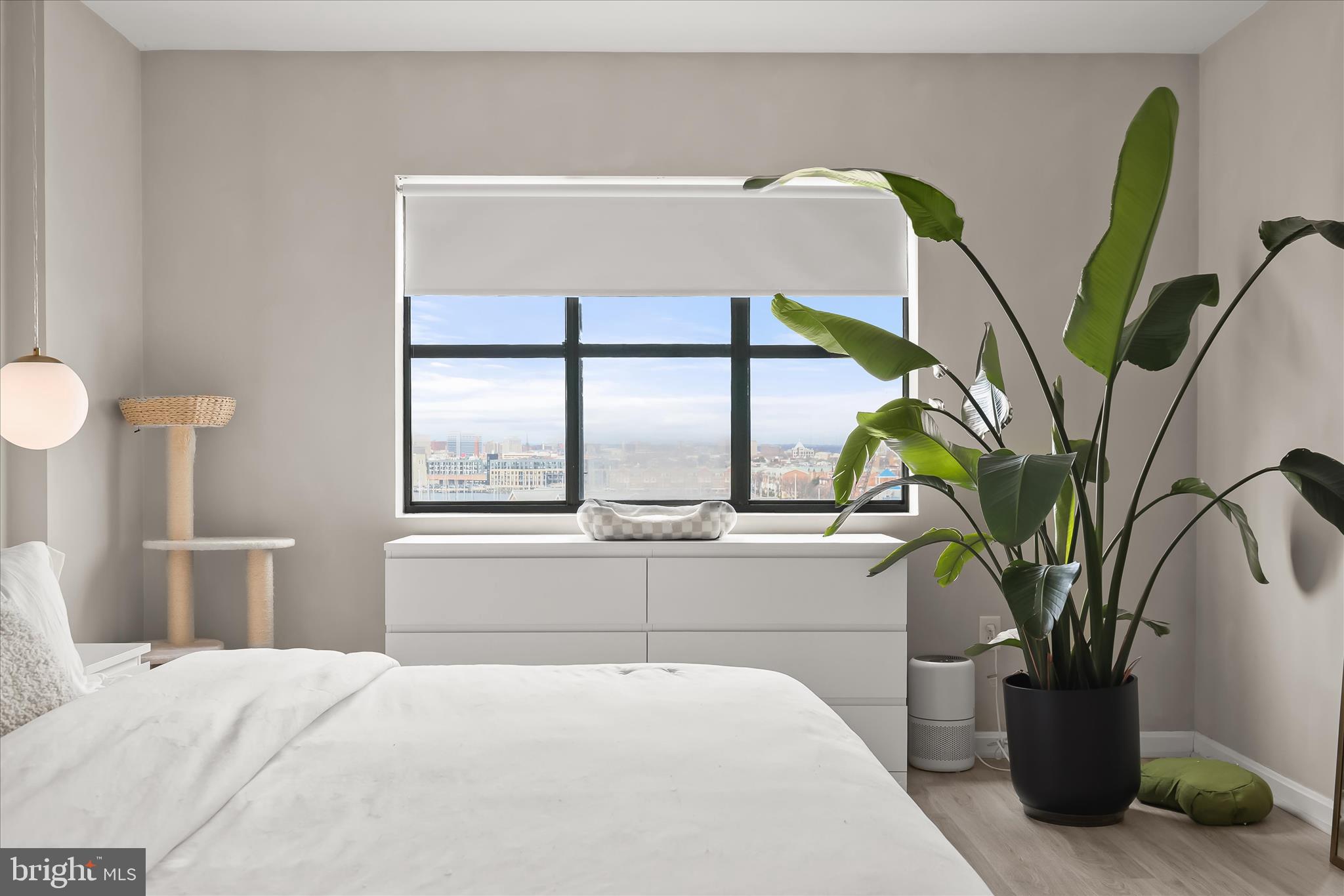 2702 Lighthouse Point East, Unit 522 Baltimore, MD 21224 - Photo 21 of 50 a bedroom with a large bed and a potted plant