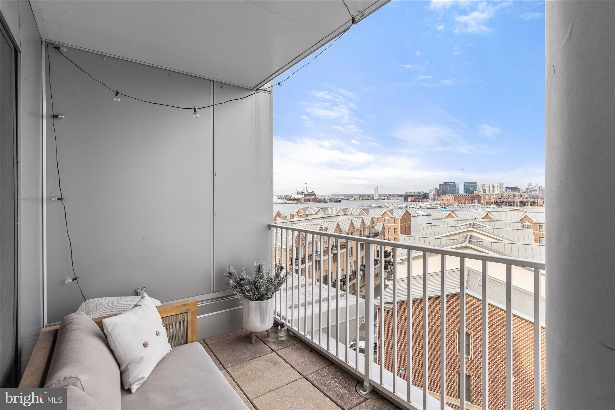 2702 Lighthouse Point East, Unit 522 Baltimore, MD 21224 - Photo 31 of 50 a view of a balcony with couches and wooden floor