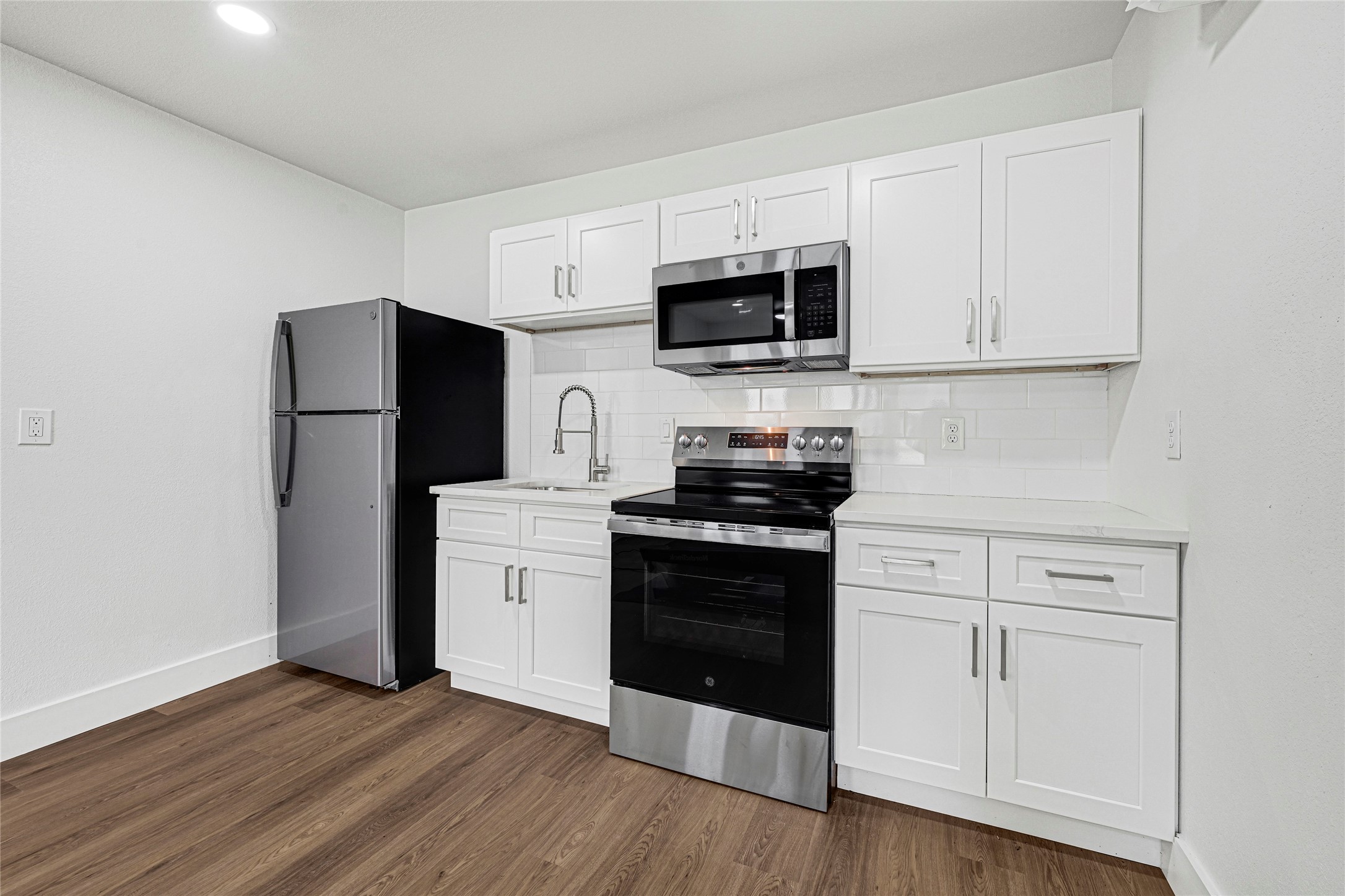 1107 Brooks Street Houston, TX 77009 - Photo 25 of 30 a kitchen with stainless steel appliances white cabinets and a stove top oven