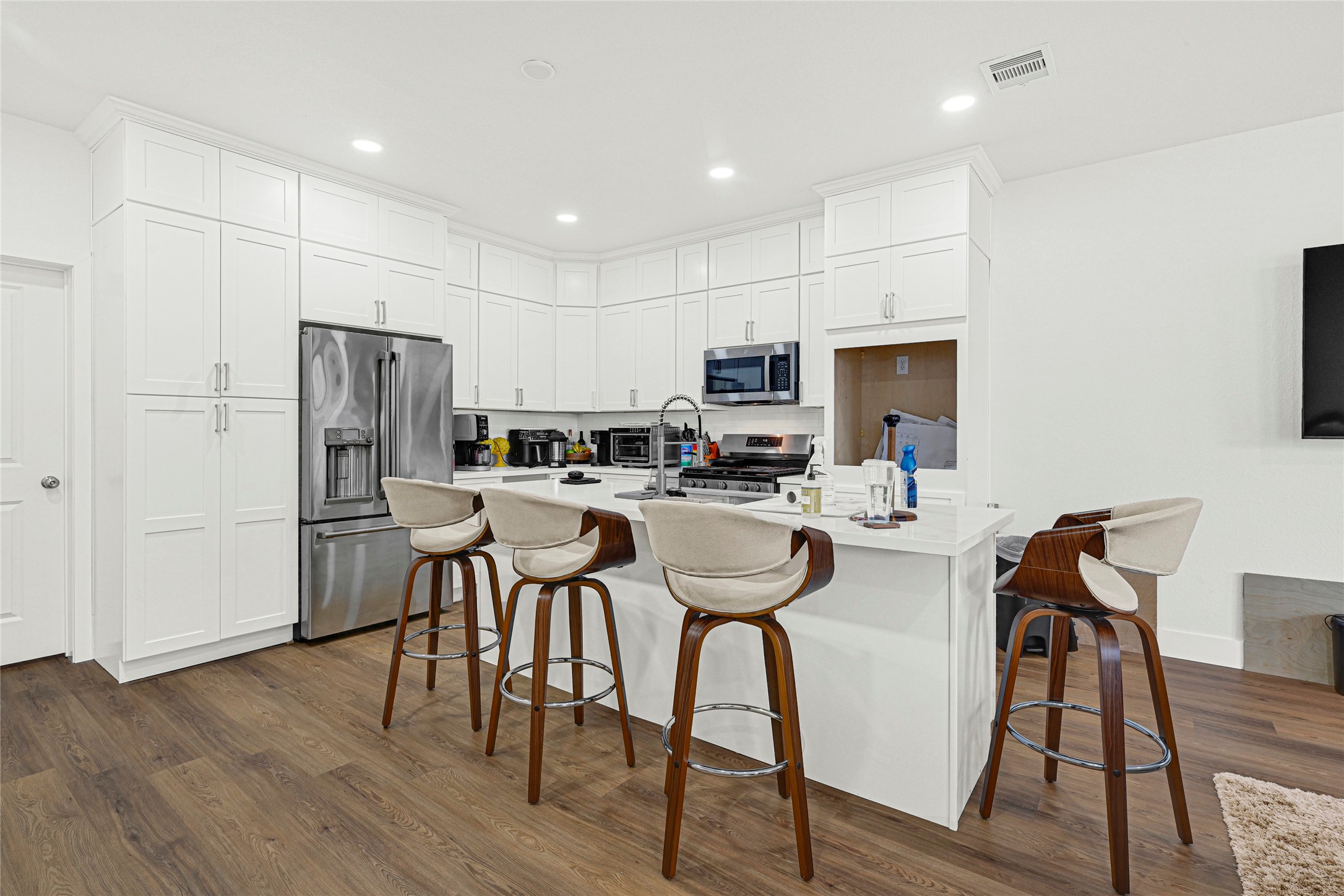 1107 Brooks Street Houston, TX 77009 - Photo 7 of 30 a kitchen with stainless steel appliances a refrigerator a stove top oven a sink dishwasher and a dining table with wooden floor