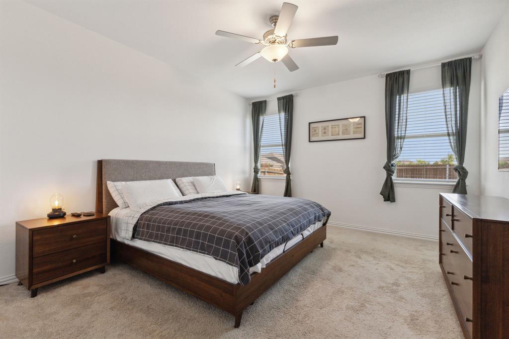 705 Alden Drive Princeton, TX 75407 - Photo 11 of 26 a spacious bedroom with a bed and a chandelier