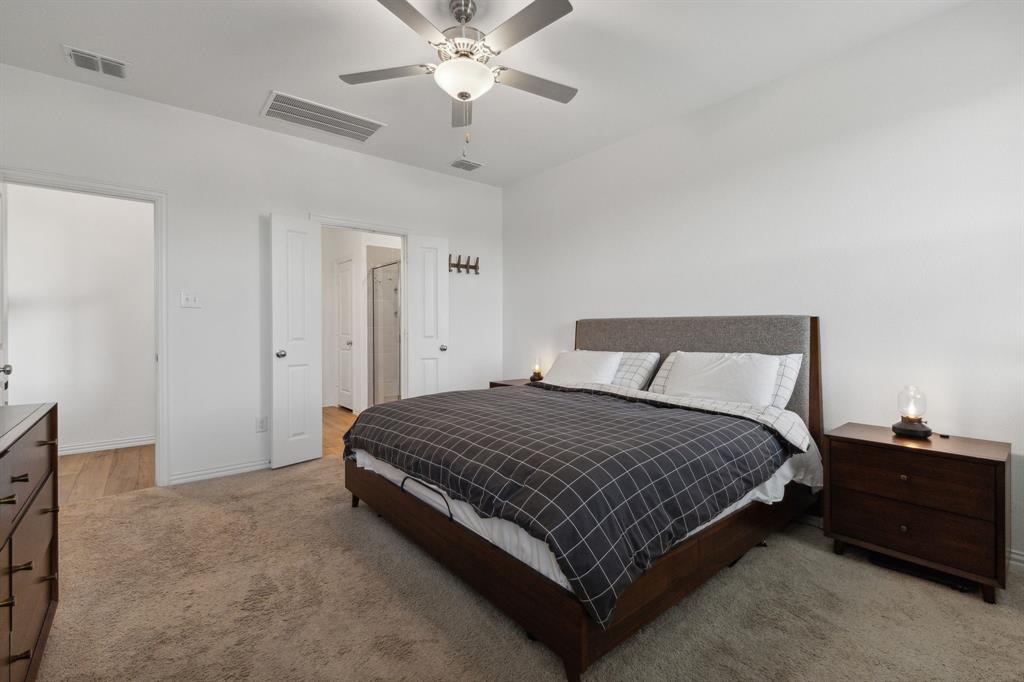 705 Alden Drive Princeton, TX 75407 - Photo 12 of 26 a spacious bedroom with a bed and a chandelier