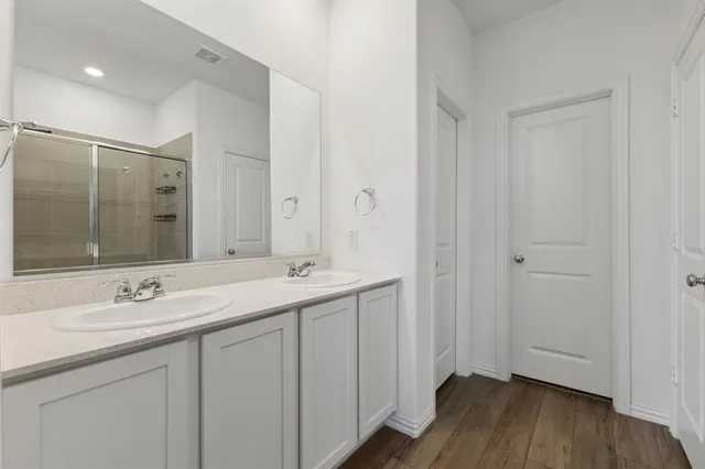 a bathroom with a double vanity sink and mirror