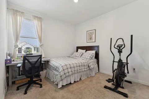 a bedroom with a bed and a desk chair