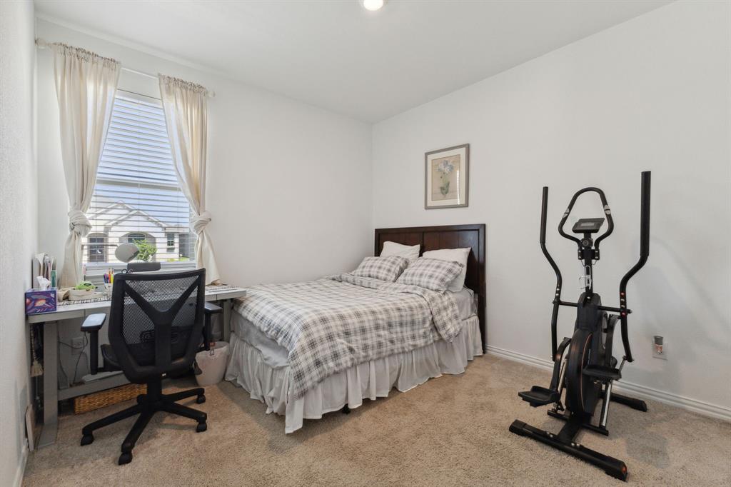 705 Alden Drive Princeton, TX 75407 - Photo 17 of 26 a bedroom with a bed and a desk chair