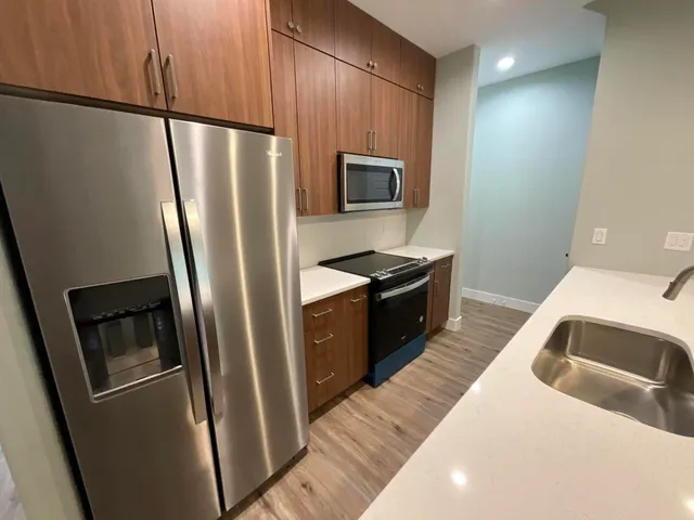 a kitchen with stainless steel appliances a refrigerator a stove a sink and a refrigerator