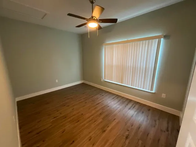 wooden floor in an empty room with a window