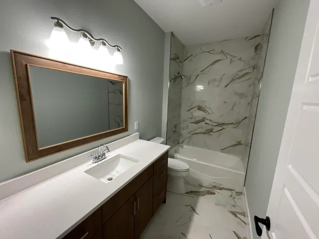 a bathroom with a sink double vanity mirror and a bathtub