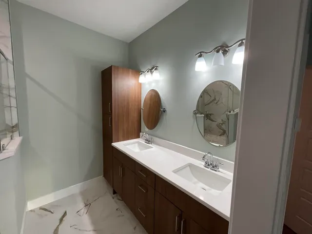 a bathroom with double vanity and a mirror