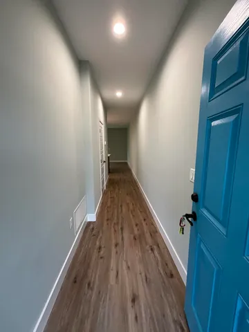 a view of hallway with stairs and wooden floor